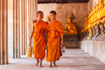 Dos novicios andando en un antiguo templo en la provincia de Ayutthaya, Tailandia