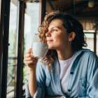 Mujer pensando en la vida mientras toma un café